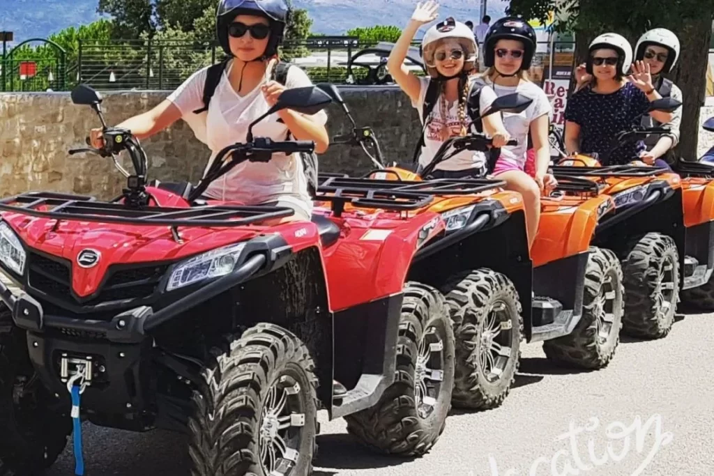 Guests wearing helmets and sitting on quad bikes on Brač
