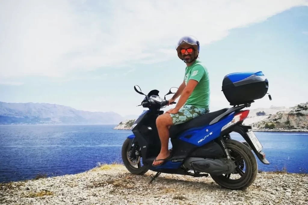 Scooter rider stopping beside a panoramic sea view on Brač